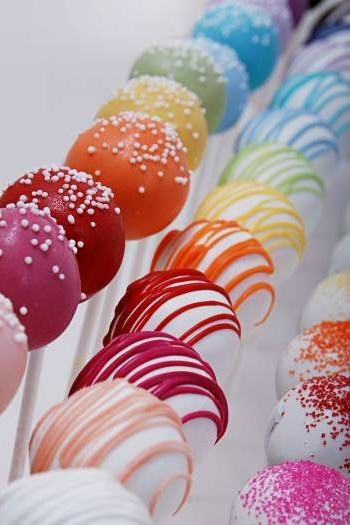 Cake pops decorated with white and rainbow icing